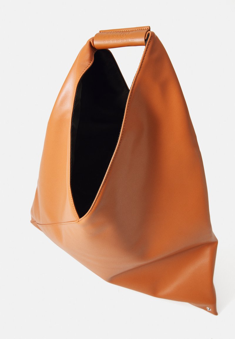 Tan leather triangular handbag with a wide handle and an open top, showing a black interior lining.