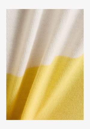 Nærbilde av mykt strikket stoff med horisontale hvite og gule striper og synlig tekstur.