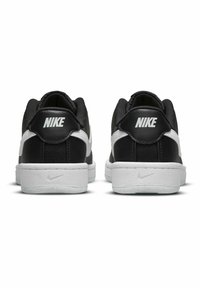 Sapatilhas Nike em preto e branco com um upper em pele texturizada, colarinho acolchoado, swoosh branco em contraste e logótipo no calcanhar.