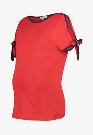 Red maternity top with navy trim and short sleeves tied with bows on the shoulders, featuring a round neckline.