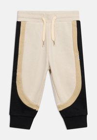 Μπεζ παντελόνια jogging με μαύρες και καφέ πλευρικές λεπτομέρειες, ribbed μανσέτες στους αστραγάλους, εμπρόσθιες τσέπες και μπεζ κορδόνι στη μέση.