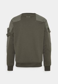 Sweat-shirt vert foncé à manches longues avec poignets et ourlet côtelés, présentant des renforts en tissu et une poche boutonnée sur les manches supérieures.