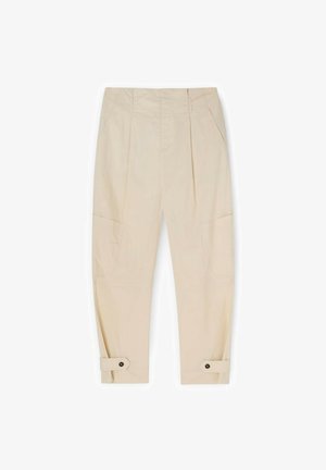 Beżowe zwężane spodnie z plisami z przodu, kieszeniami po bokach, zapinanymi na guziki paskami przy kostkach oraz ukrytym przednim zapięciem.