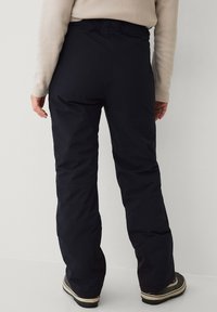 Zwarte waterdichte broek met een relaxed fit, elastische tailleband en versterkte zoom. Het materiaal lijkt glad met een matte afwerking.