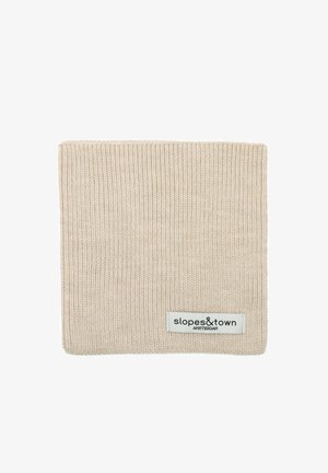 Bandeau en tricot beige avec une texture côtelée et une étiquette logo portant l'inscription "slopes&town" sur un côté, de forme rectangulaire.