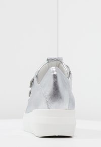 Zilveren leren sneaker met een gladde textuur, ronde achterkant en contrasterende witte platformzool. Beschikt over een kort, grijs vetersdetail.