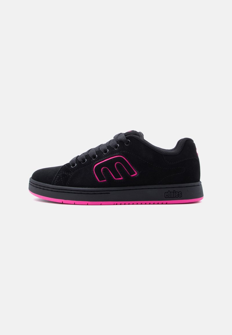 Zwarte lage sneaker met roze zool en roze omrand logo "M", zwarte veters en "etnies" merknaam op de zool.