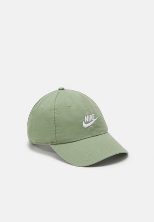 Casquette de baseball verte Nike avec une visière incurvée et un logo blanc brodé à l'avant, présentée sur un fond clair uni.