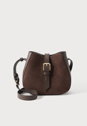 Bruine suède crossbodytas met donkere leren randen en band, met een gouden gespdetail aan de voorste band.