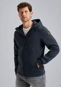 Mørkeblå lynlås sweatshirt med hætte, der har en frontlomme, sidelommer og logo-detaljer. Stoffet ser blødt og glat ud.
