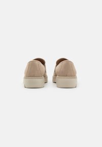 Beige semskinn sneakers med avrundet form, gummisåle og minimalt med sømmer. Hælen har en teksturert aksent for bedre grep.