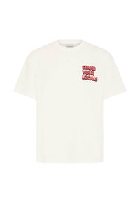 T-shirt blanc à manches courtes avec le texte rouge et noir "STAND YOUR LOCALS" imprimé sur la partie supérieure gauche de la poitrine.