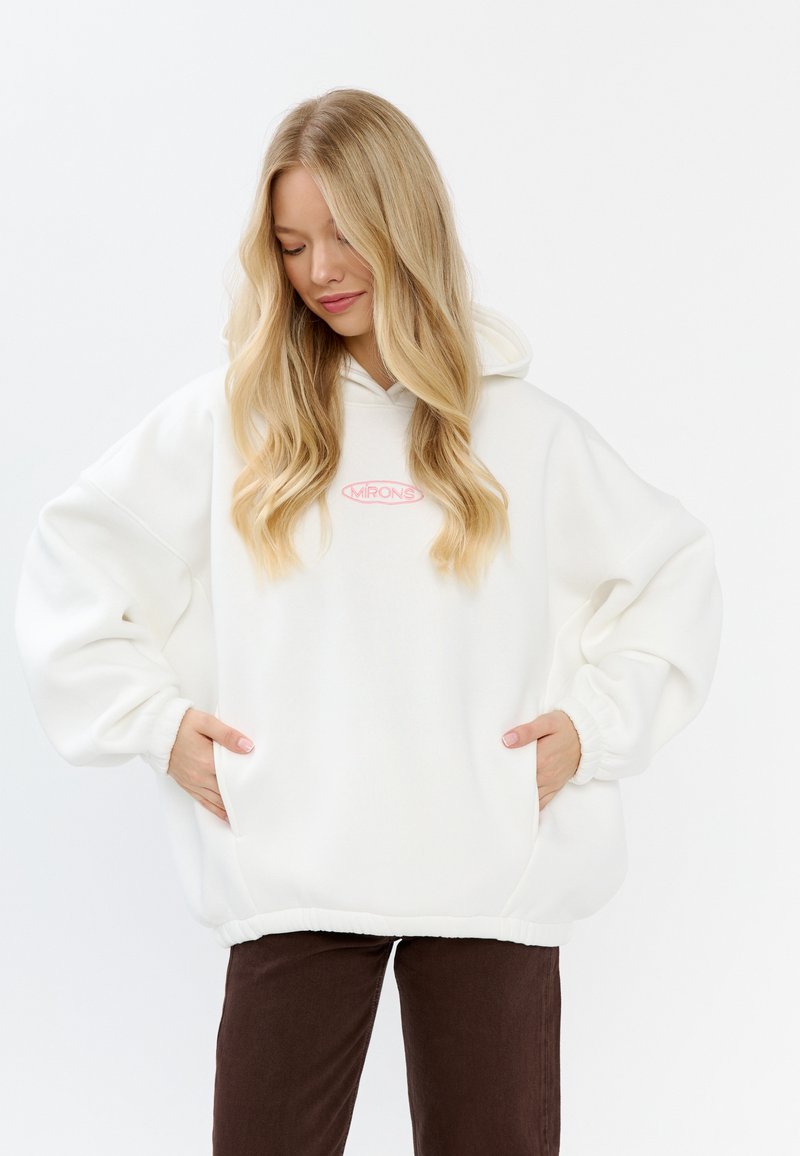 Felpa oversized bianca realizzata in morbido tessuto, con un logo rosa all'interno di un ovale al centro, polsini a coste e orlo con coulisse.