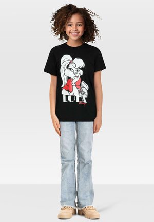 Svart bomull T-skjorte med en tegneseriefigur i hvitt og rødt med teksten "LOLA Bunny". Kombinert med lyseblå, vid flarejeans og beige sko.