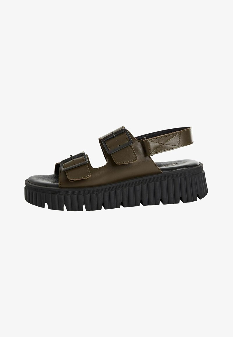 Brown sandals with a chunky black platform sole, featuring two adjustable buckle straps and an open-toe design.