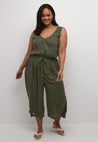 Olive green jumpsuit with a loose fit, sleeveless design, and adjustable drawstring waist. Soft texture, cropped wide legs, and subtle sheen.
