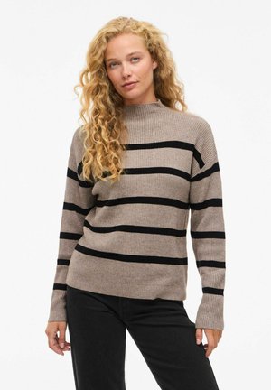 Randig tröja i beige och svart med hög krage och ribbad textur. Långa ärmar och avslappnad passform, med horisontella ränder.