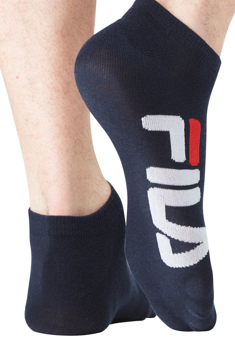 Chaussettes chevilles bleu marine en mélange de coton, avec un imprimé du logo "FILA" en blanc et rouge sur le côté. Texture lisse, ajustement serré autour de la cheville.