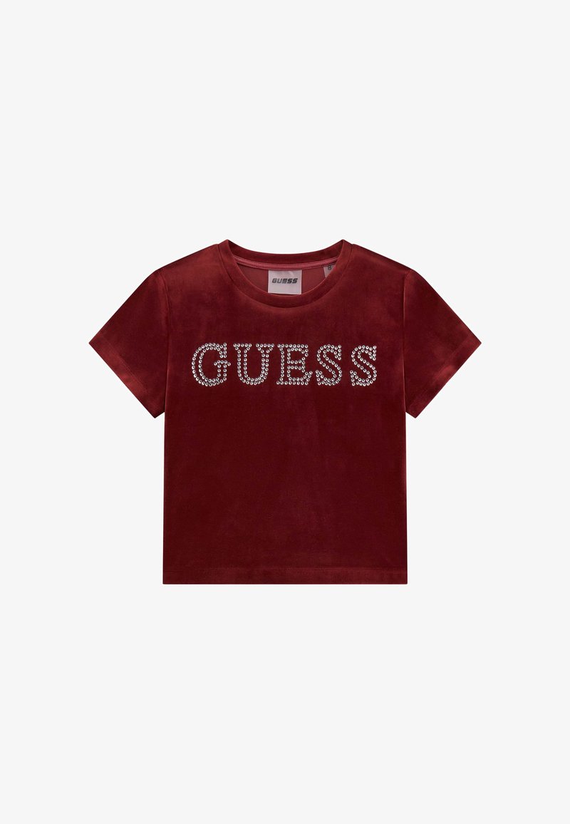 Korte rode fluwelen t-shirt met een ronde hals en korte mouwen, versierd met duidelijke rhinestones die "GUESS" over de voorkant spellen.
