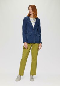 Denim blazer in donkerblauw met gestructureerde revers en twee voorzakken, gecombineerd met olijfgroene cargobroek met zijzakken en een relaxte pasvorm.