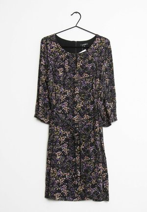 Abito nero con piccola stampa floreale viola, rosa e gialla, maniche a tre quarti, scollo rotondo e cintura in vita, appeso a una gruccia nera.