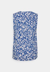 Top sans manches bleu avec un motif floral composé de fleurs blanches et rouges. Fabriqué en tissu léger ; le dos présente un subtil détail de fronces.