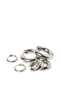 Sølvmetal hoop ringe i forskellige størrelser, med en blank overflade og glatte kanter, arrangeret i en spredt formation.