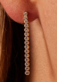 Goldene Ohrhänger mit einem linearen Design, das mehrere klare, rund geschliffene Edelsteine in einer Reihe entlang der Länge zeigt.