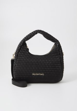 Black handbag made of textured material with a twisted handle and gold logo detail. Features zipper closure and an additional shoulder strap.