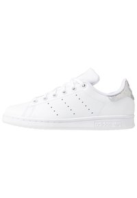 Vit lädersneaker med rund tå, platta snören, perforerade detaljer på sidan och en holografisk accent på hälen.