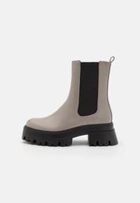 Gray leather ankle boot with elastic black side panels, thick black platform sole, and a pull tab at the back for easy wear.
