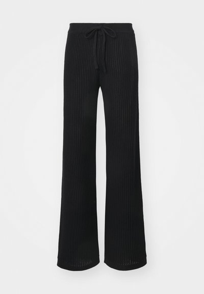 Pantaloni negri, cu picioare largi, din țesătură ribbed, având talie cu șnur și manșete deschise. Textura pare moale și respirabilă.