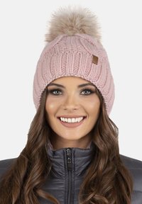 Roze gebreide muts met een fluffy pompon bovenop, met een gestructureerd ribbelontwerp. Draag met een donkergrijze ritselfleece jacket.