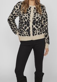 Cardigan avec imprimé léopard en noir et beige, en maille, bords côtelés, fermeture à boutons à l'avant.