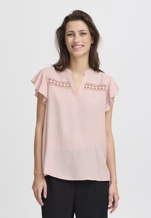 Hellrosa Bluse mit kurzen Rüschensleeves, V-Ausschnitt und dekorativen Spitzeing Details über der Brust. Glatter Stoff und lockerer Schnitt.