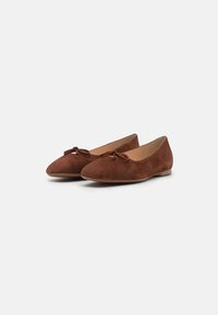Ballerines en daim marron avec un bout pointu et un petit nœud accent sur le dessus. Doublure intérieure lisse et semelle plate.