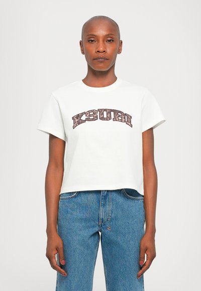 T-shirt blanc court en coton, ornée d'un grand logo marron "KSUBI". Manches courtes, col rond et coupe décontractée.