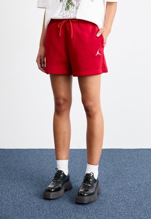 Red cotton shorts with an elastic waistband and drawstring, featuring side pockets and a white Jordan logo embroidered on the hem.