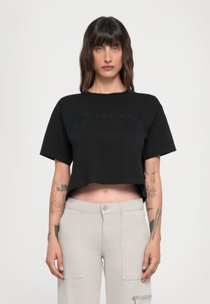 Svart cropped t-skjorte med korte ermer, med embossert "MICHAEL KORS" logo. Mykt bomullsstoff, avslappet passform, ingen mønstre eller hardwaredetaljer.