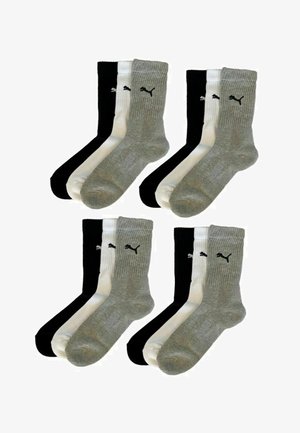 Four sets of three Puma crew socks in black, white, and gray, arranged in pairs with the Puma logo on each sock.