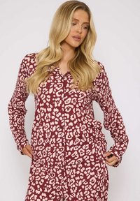 Bordeaux pyjamapakket met een crème abstract panterprint, met lange mouwen, knoopsluiting en een ontspannen pasvorm.