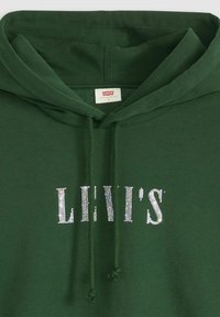 Sudadera verde de algodón con una textura suave. Presenta una capucha con cordón y un logo "LEVI'S" adornado con rhinestones en blanco.