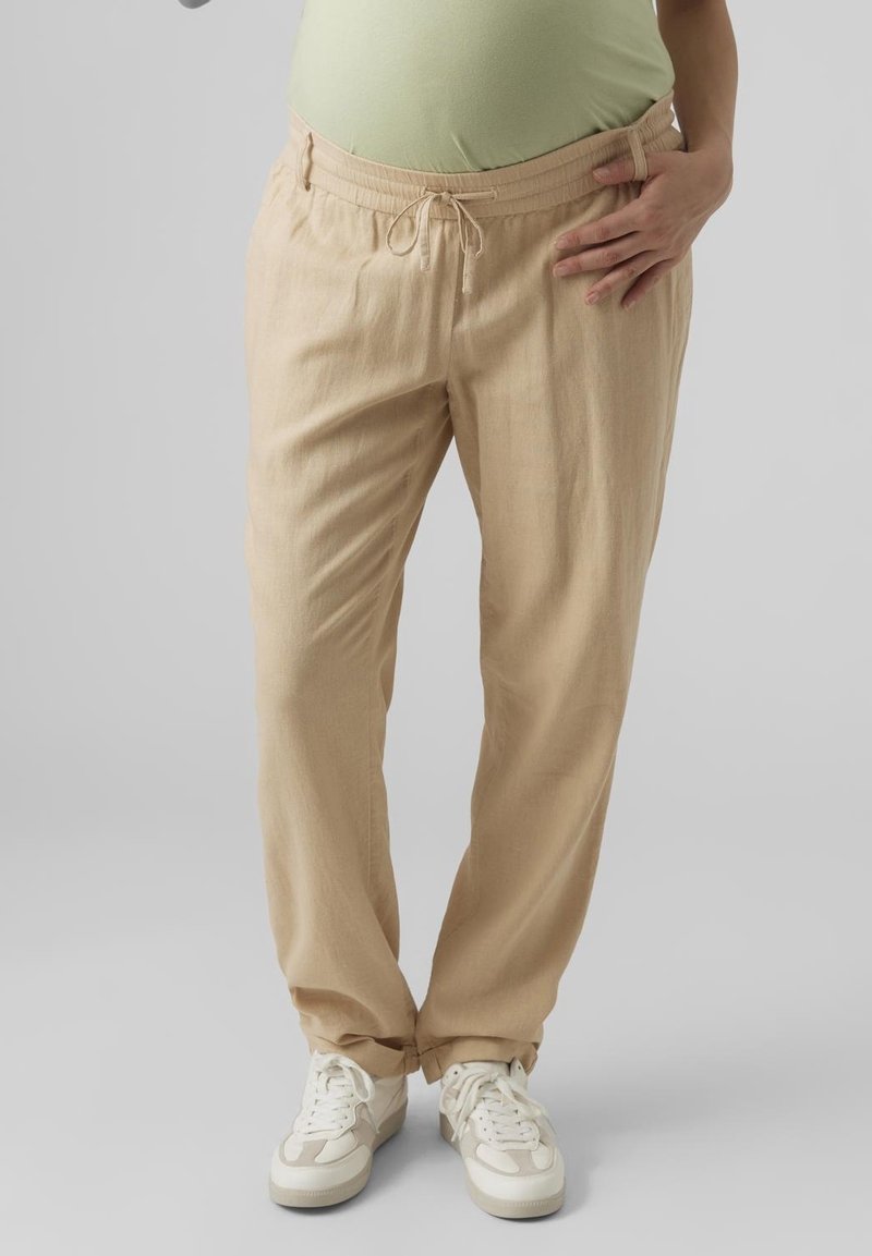 Pantalon beige ample avec une taille élastique et un cordon de serrage. Le tissu semble léger avec une finition légèrement texturée.