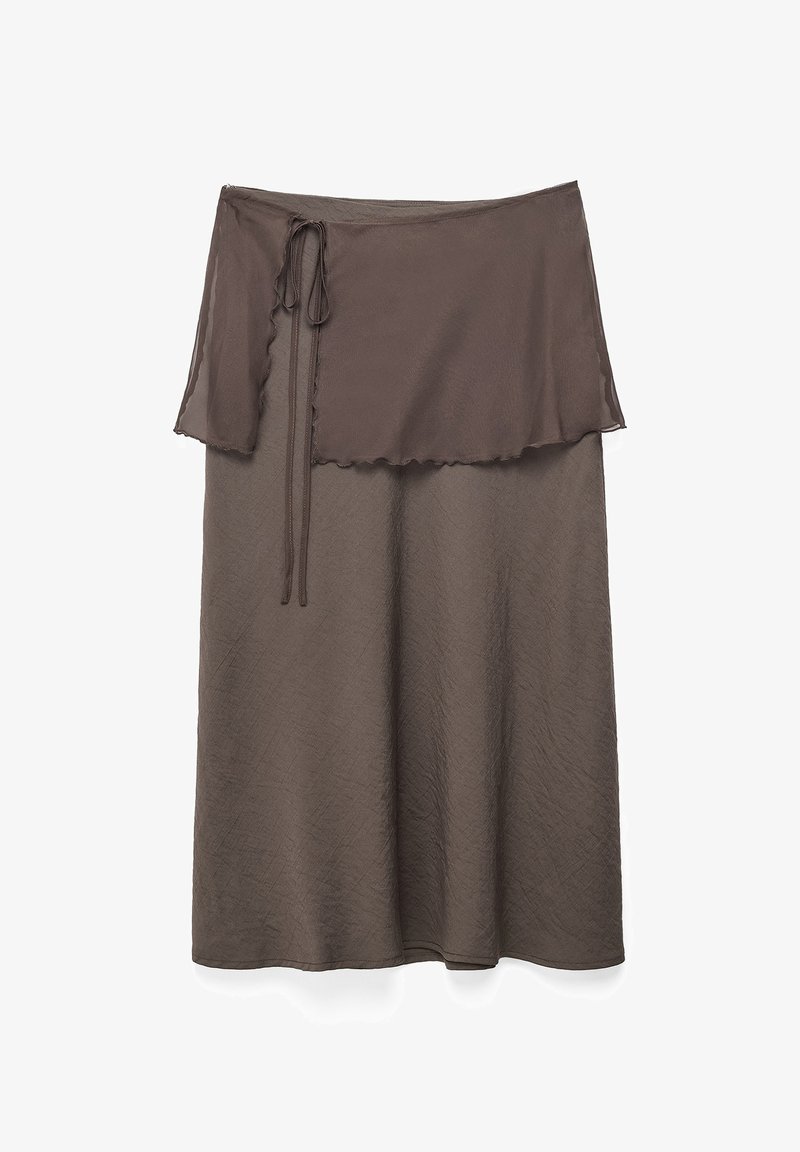 Brązowa midi spódnica z przezroczystą narzutką typu wrap, wiązaną kokardą po lewej stronie, wykonana z delikatnie fakturowanej tkaniny.