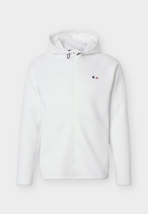 Biała bluza z kapturem na zamek błyskawiczny, z regulowanym sznurkiem oraz małym haftowanym niebiesko-czerwonym logo krokodyla na lewej piersi.