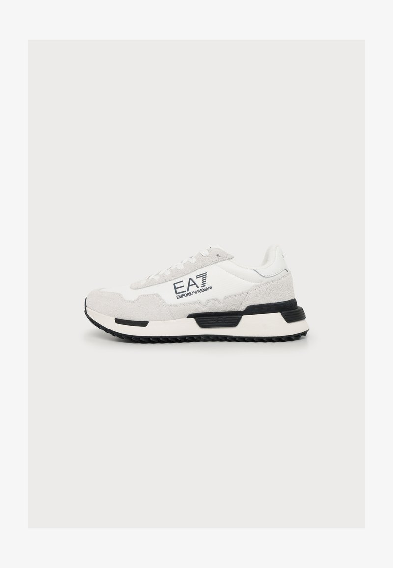 Λευκό και ανοιχτό γκρι sneaker Emporio Armani EA7 με μαύρες λεπτομέρειες στη σόλα και σήμανση στο πλάι, εμφανίζεται σε απλό φόντο.
