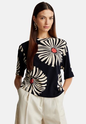 Blusa a maniche corte di colore blu navy con grandi motivi floreali beige e accenti rossi. Tessuto morbido, vestibilità rilassata, scollatura tonda e dettaglio con nodo laterale.