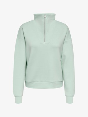 Sweat-shirt vert menthe avec col montant zippé, coupe décontractée, épaules tombantes et poignets et ourlet côtelés, confectionné en tissu doux.