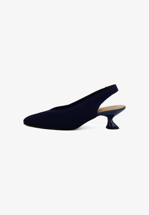 Zapato slingback azul marino con punta afilada, parte superior de punto texturizado y tacón de gatito acampanado único sobre fondo blanco.