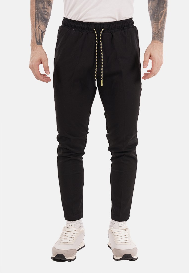 Joggers de algodón negros con cintura elástica y detalle de cordón, que cuentan con piernas ajustadas y bolsillos laterales.